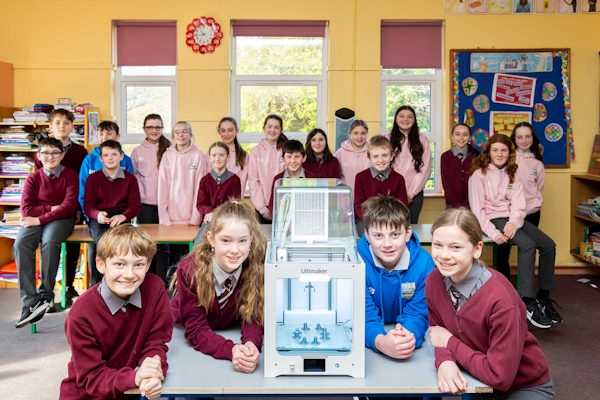 Students in classroom around a 3D printer