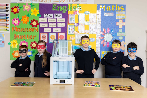 Four students with a 3D printer